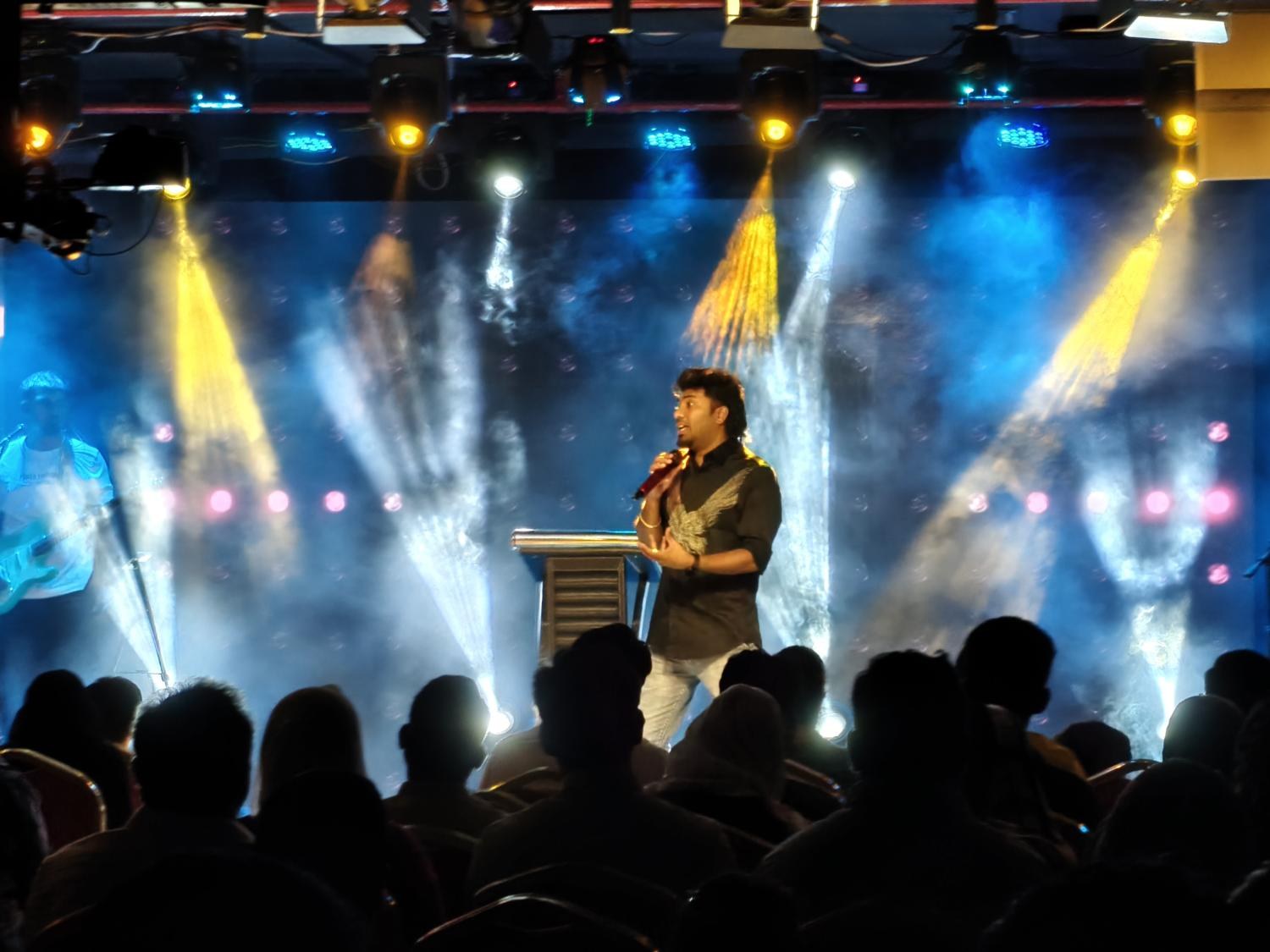 Pastor Teshy Frashans ministering under stage lights