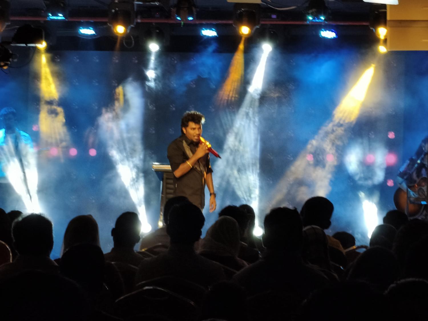 Pastor Teshy Frashans with microphone in worship
