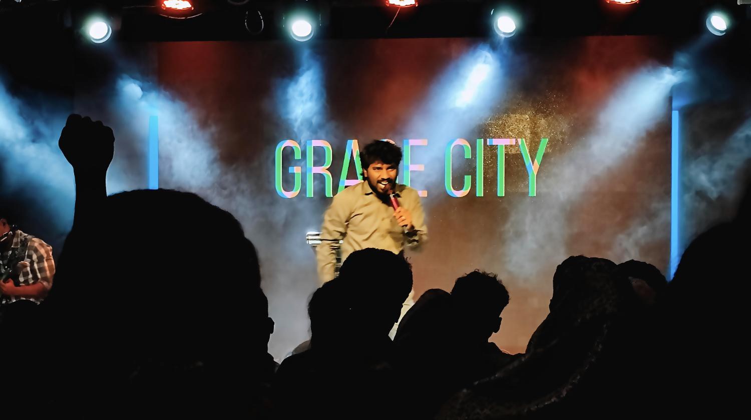 Pastor Teshy Frashans leading on stage at Grace City